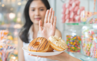 Woman in a candy shop refusing sweets